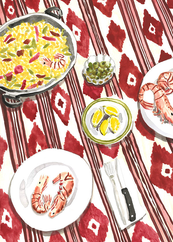 Arte da cucina: paella e gamberi su tovaglia a fantasia
