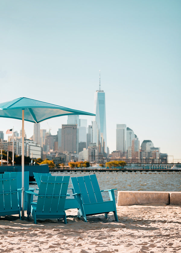 Poster di viaggio con sedie turchesi in spiaggia e skyline cittadino