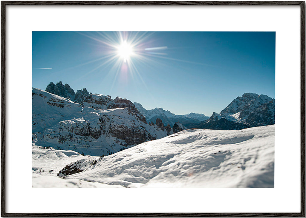 Arte paesaggistica: catena montuosa innevata con sole vivo
