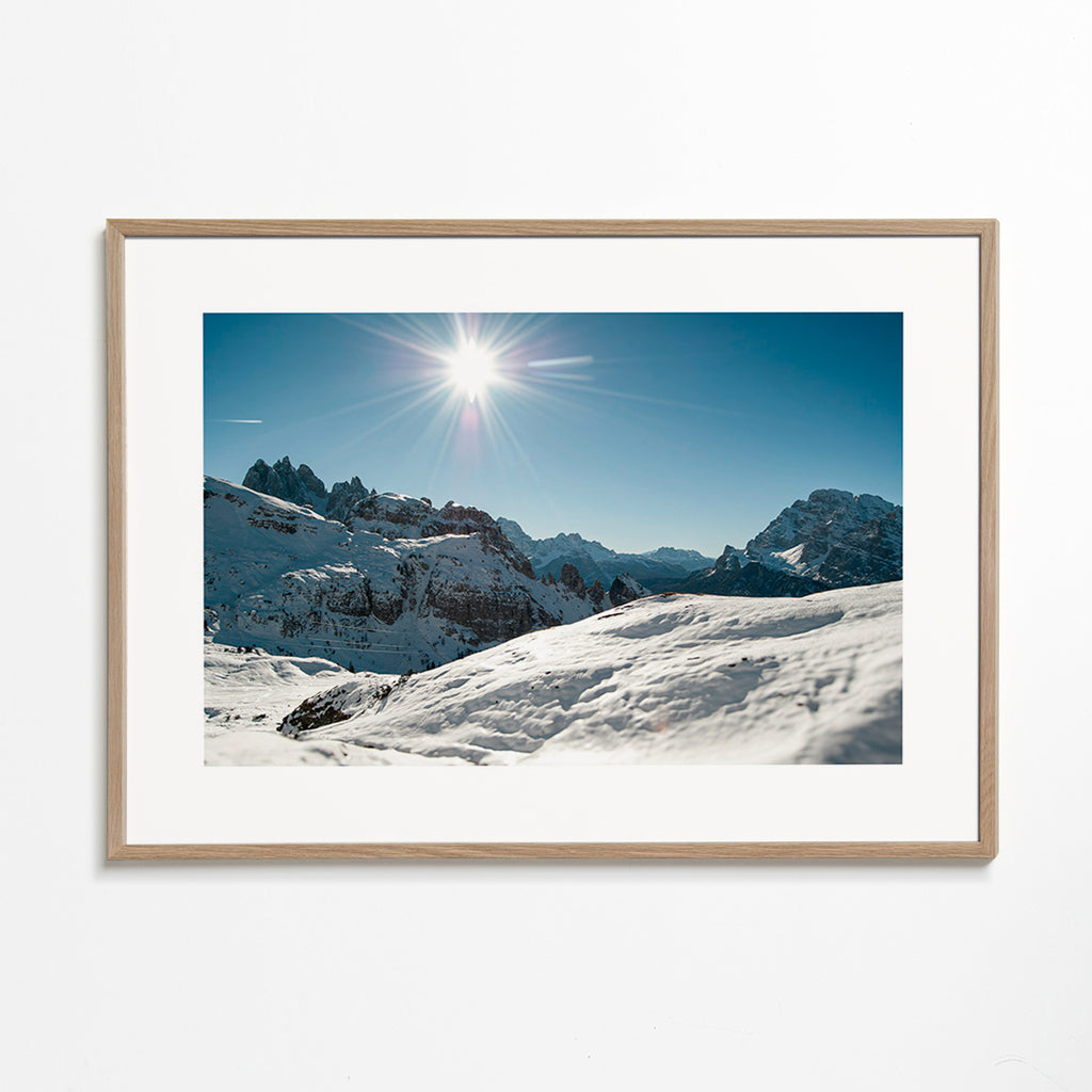 Arte paesaggistica: catena montuosa innevata con sole vivo