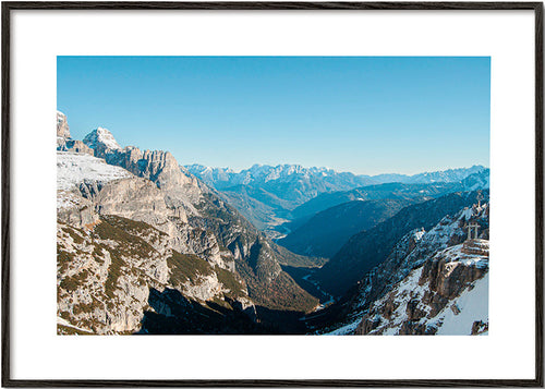 Quadro paesaggistico con valle di montagne innevate