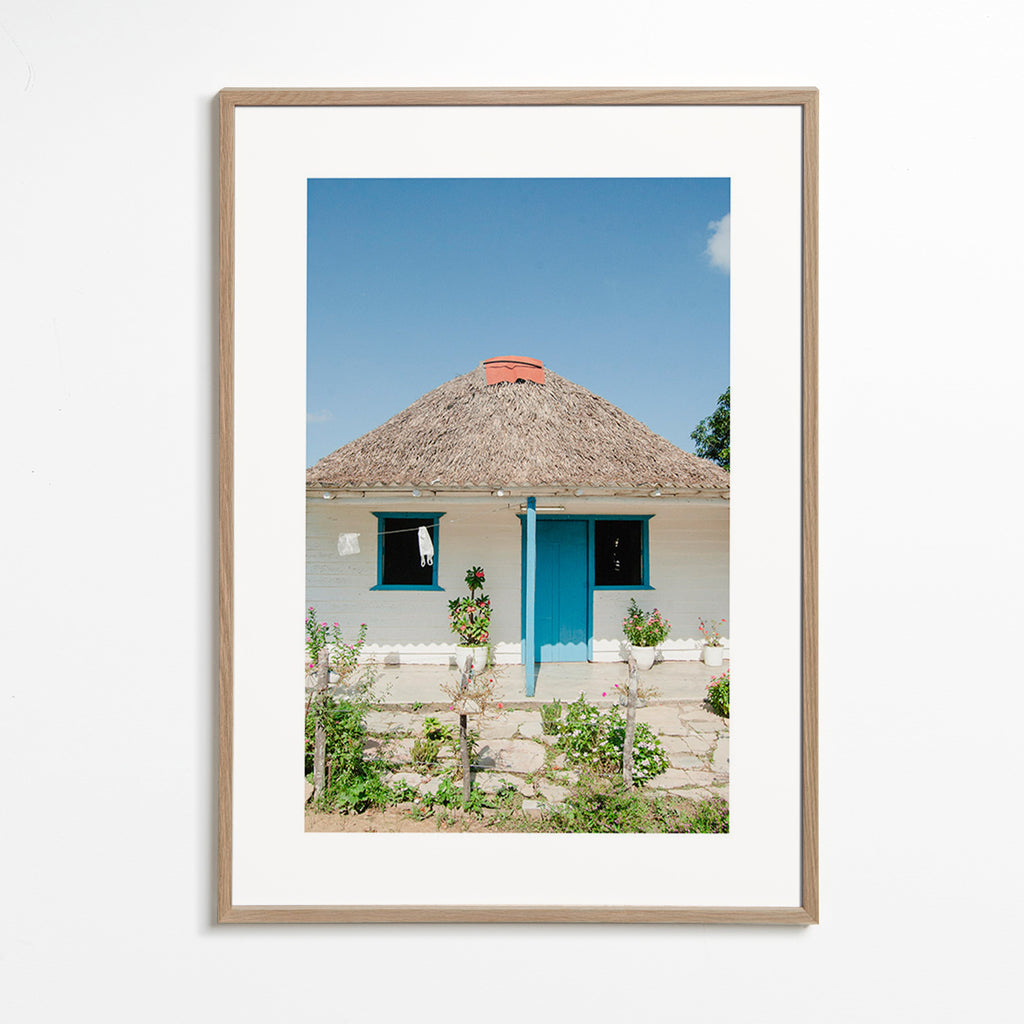 Quadro paesaggistico con casetta e porta blu