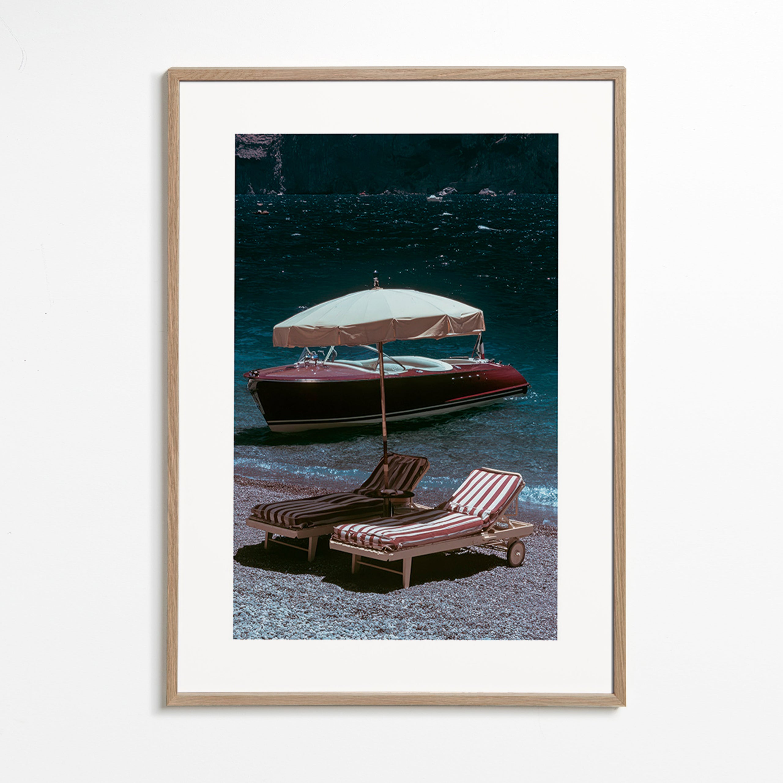 Quadro di paesaggio con barca classica e lettini in riva