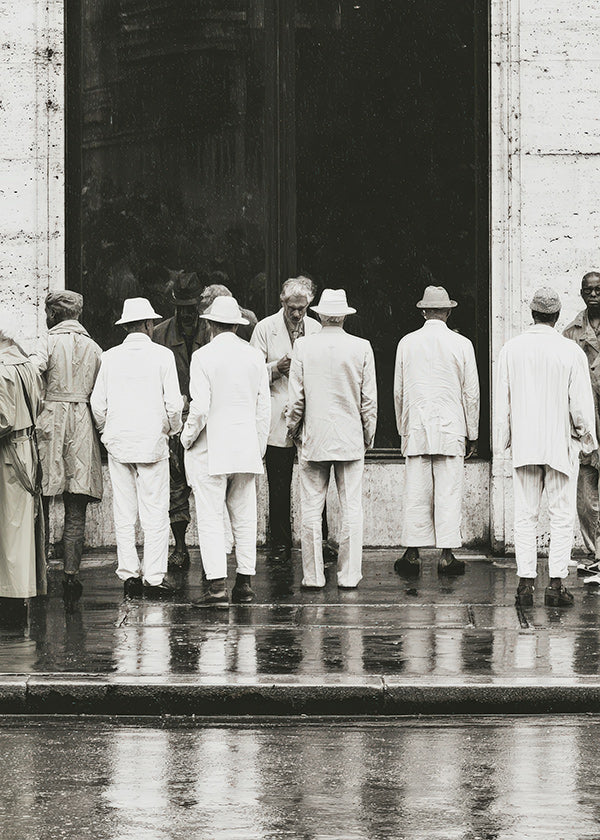 Fotografia in bianco e nero di uomini di spalle sotto la pioggia